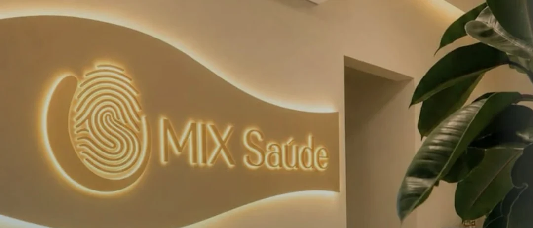 Recepção da MIX Saúde com a marca iluminada na parede e o sofá